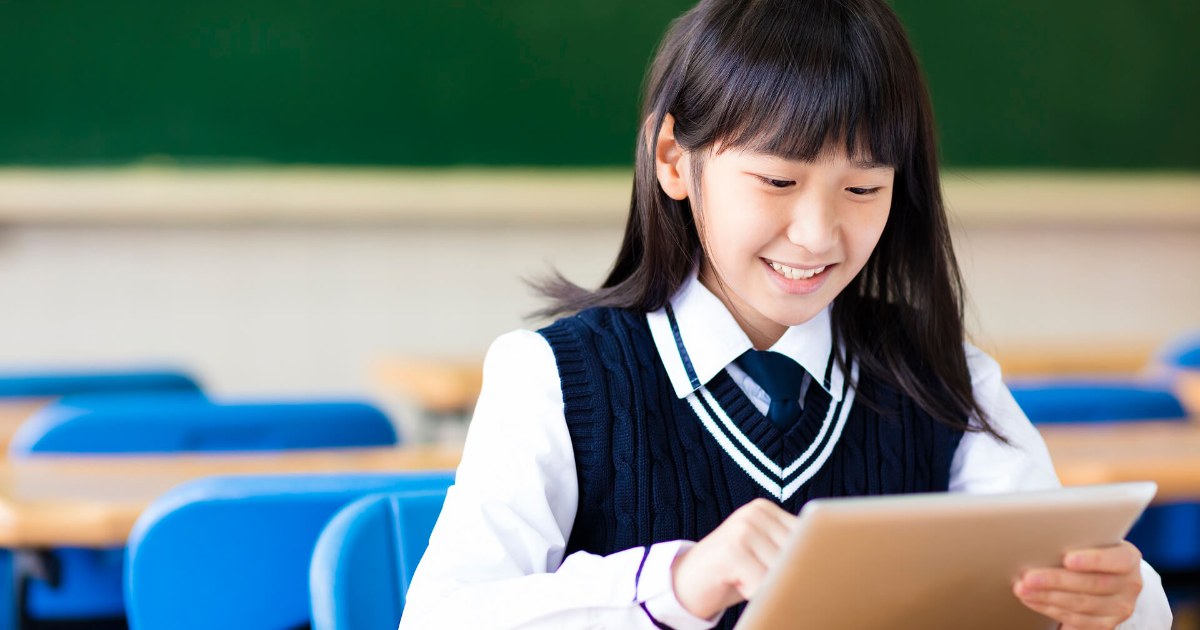 タブレットで学ぶ笑顔の生徒（NPO法人まなびとステーション）